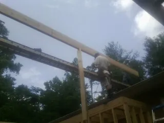 Carpenter setting a ridge beam over a new addition frame — Ice Dam Removal by Roofing Brothers in Hawley